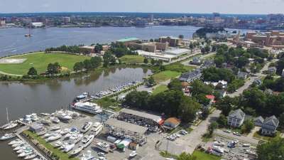 Aerial view of a marina and waterfront neighborhood in Portsmouth, Virginia with the Norfolk skyline across the Elizabeth River
