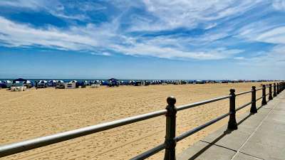 The Virginia Beach oceanfront boardwalk and beach under a blue sky