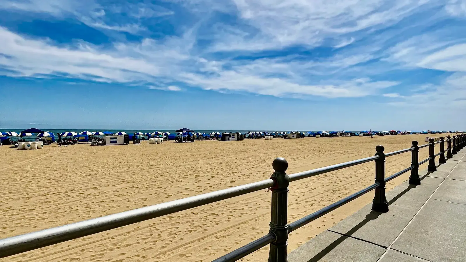 The Virginia Beach oceanfront boardwalk and sandy Atlantic beach under a blue sky
