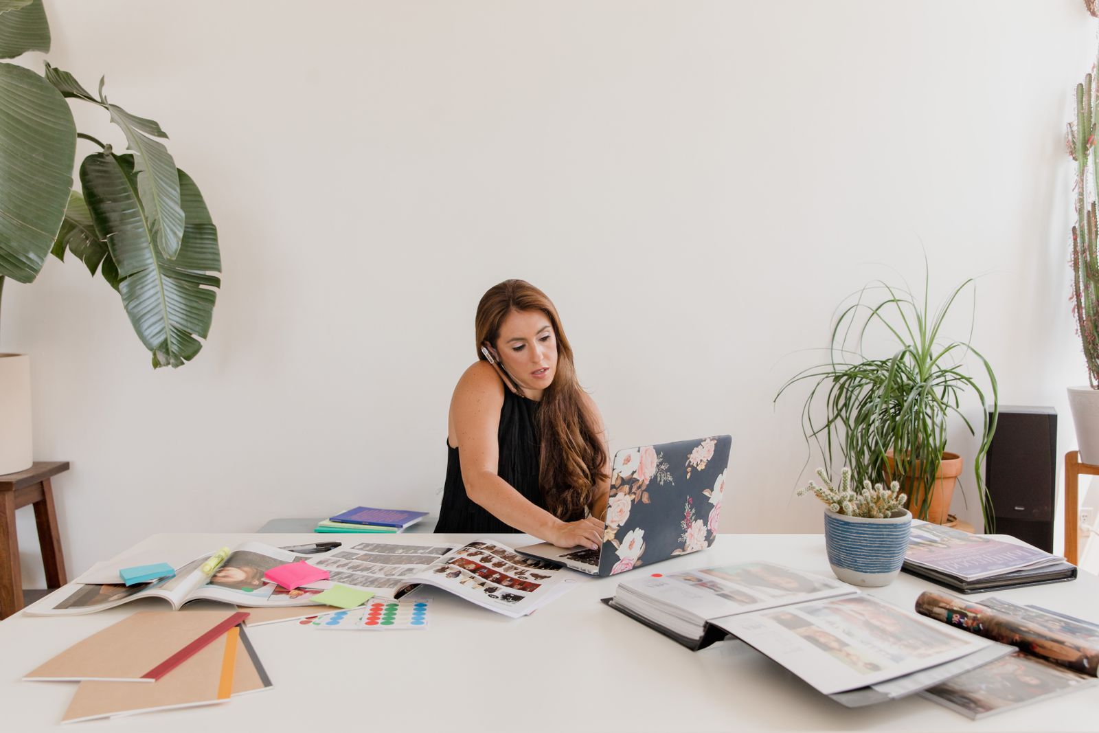 Small business owner reviewing paperwork at a laptop in a back-office workspace