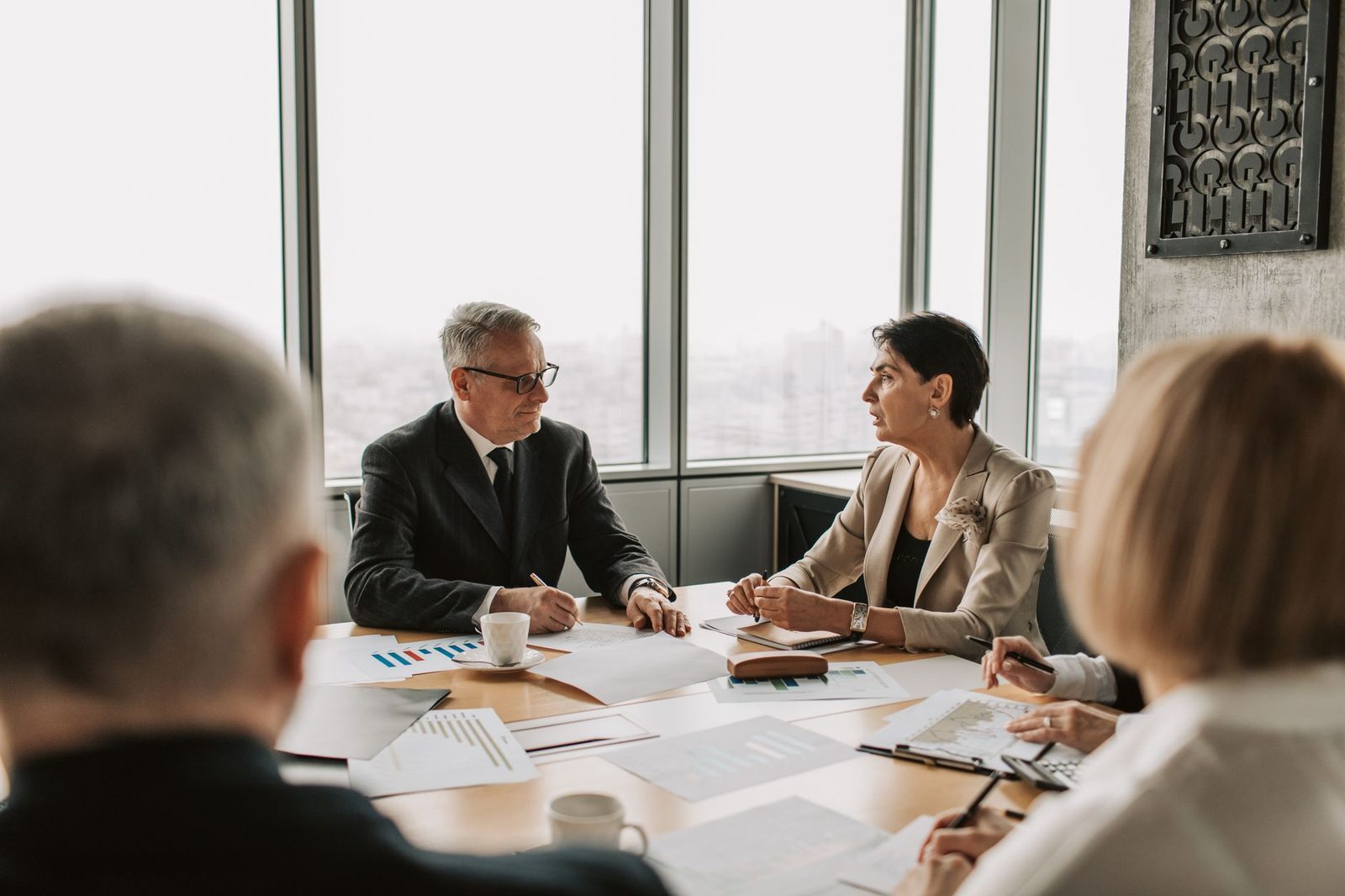 Business professionals reviewing documents together at a table during a strategy meeting in a modern office