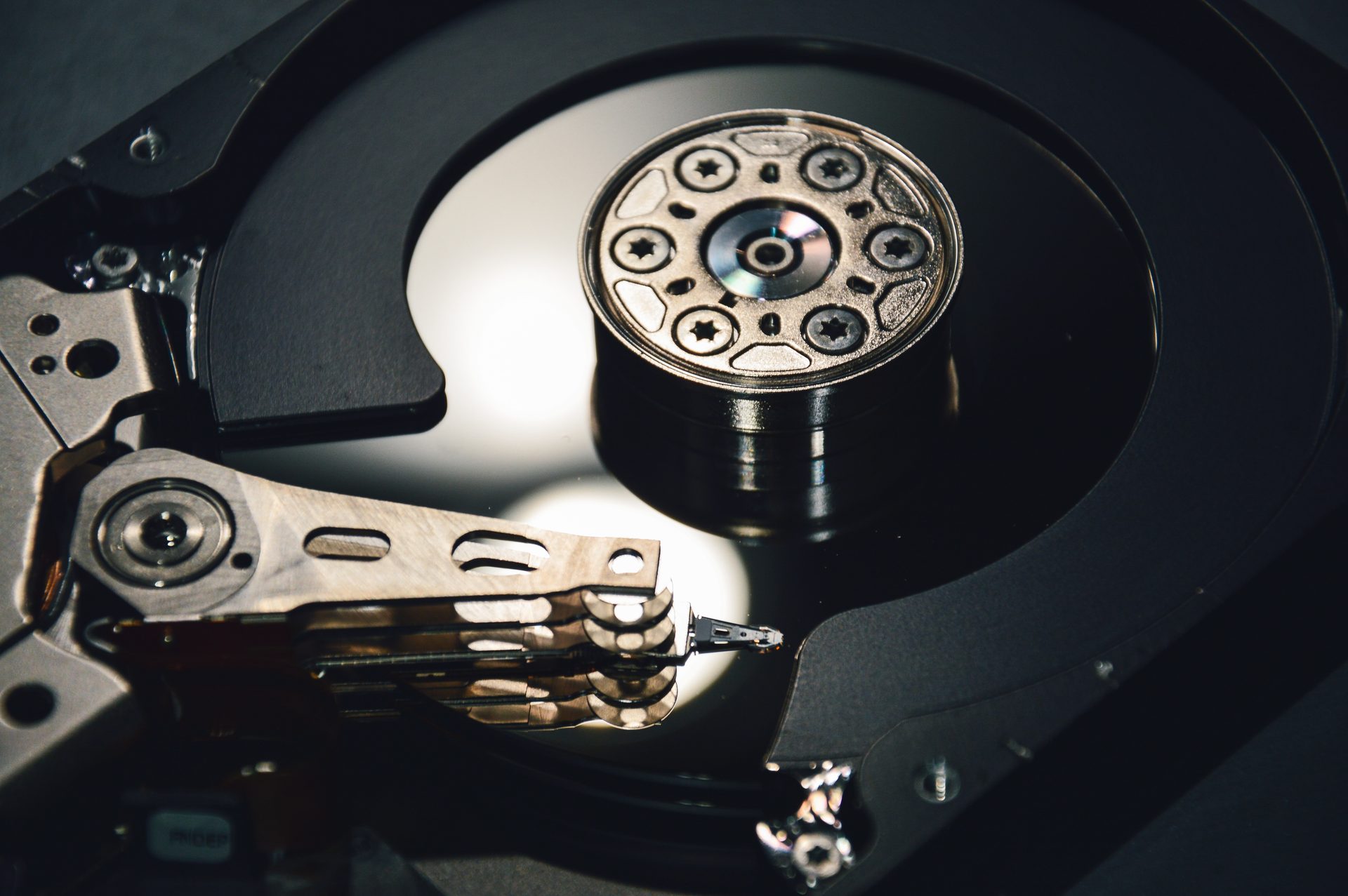 Close-up of the platter and read head inside an open hard disk drive